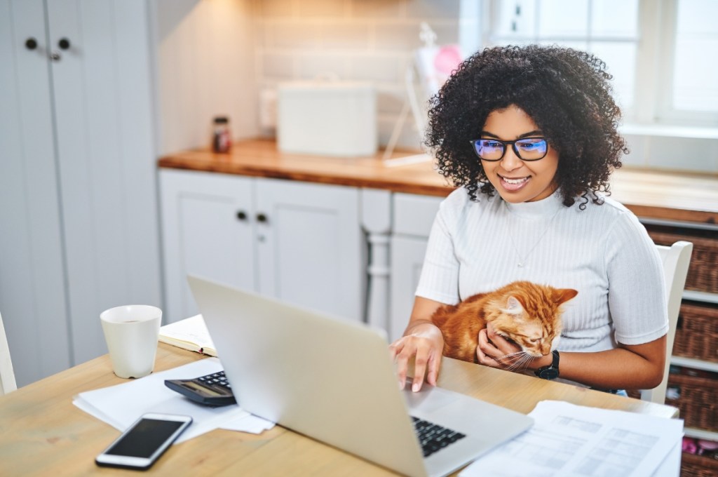 woman with cat in lap at computer