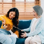 older and younger woman on couch with dog