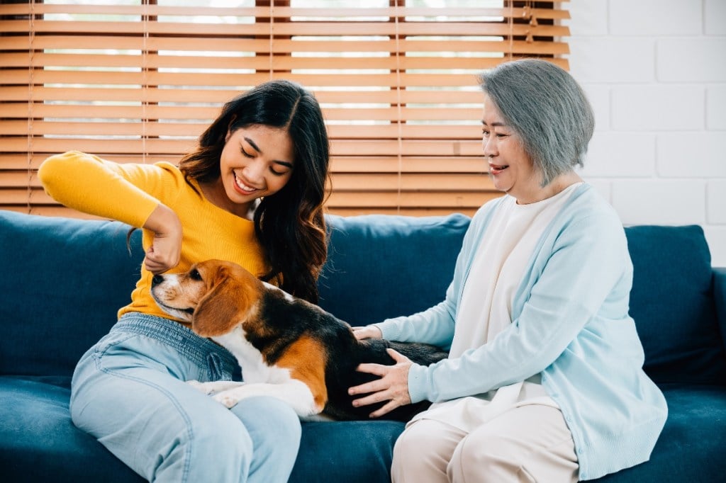 older and younger woman on couch with dog