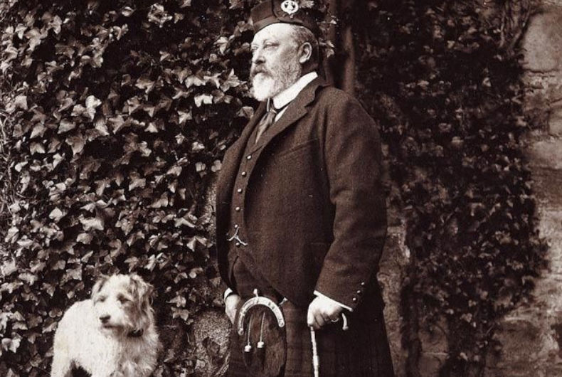 black and white photo of man in kilt with a dog